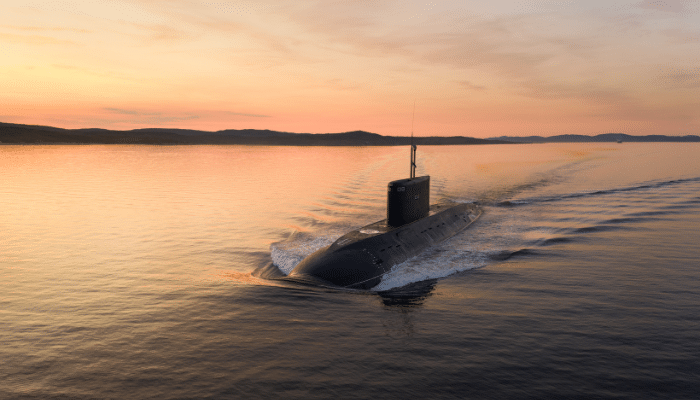 a submarine moving along the surface of the ocean during a sunset